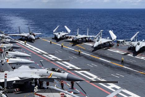 Chinese fighter jets on the flight deck of an aircraft carrier.