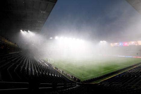 Soccer stadium covered in fog during a rain delay.