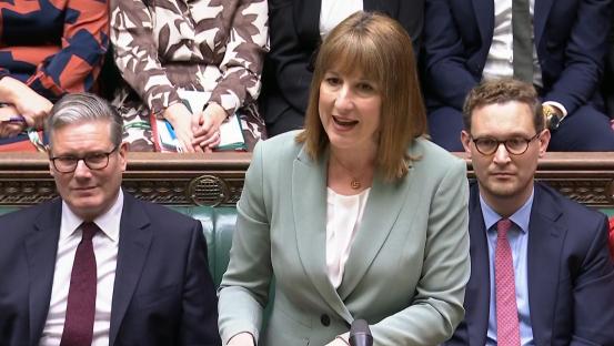 A woman in a light green blazer speaks during a live session of the Commons.