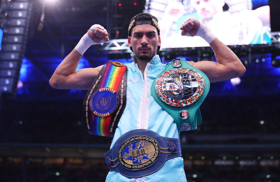 Hamzah Sheeraz celebrates his boxing victory with three championship belts.
