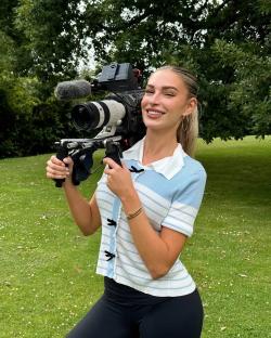 Woman holding a video camera outdoors.