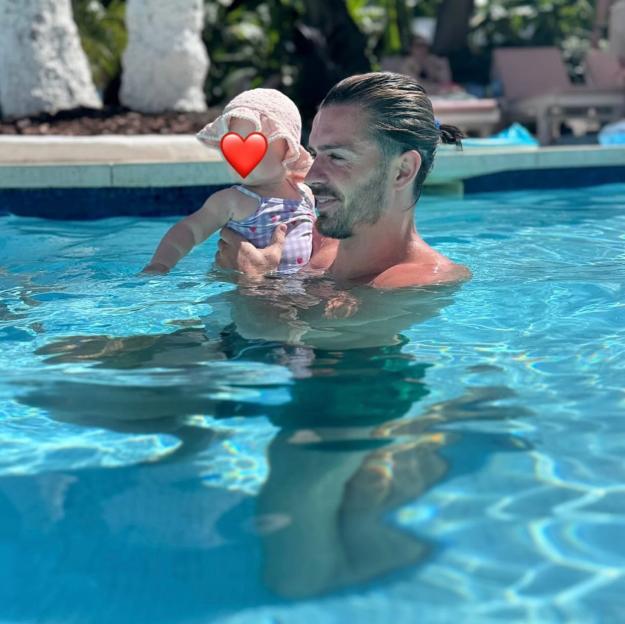 Man holding baby in swimming pool.