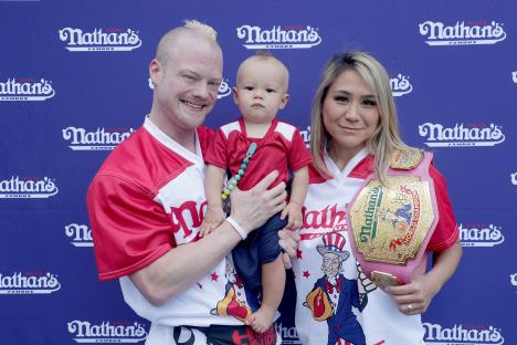 Competitive eaters Nick Wehry and Miki Sudo with their son at a Nathan's Hot Dog Eating Contest weigh-in.
