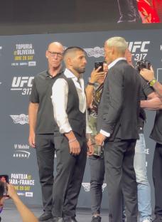 Two UFC fighters facing each other at a press conference.