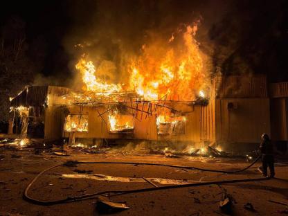 A building engulfed in flames at night.