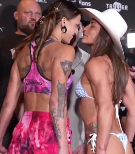 Two women kissing at a fight event.