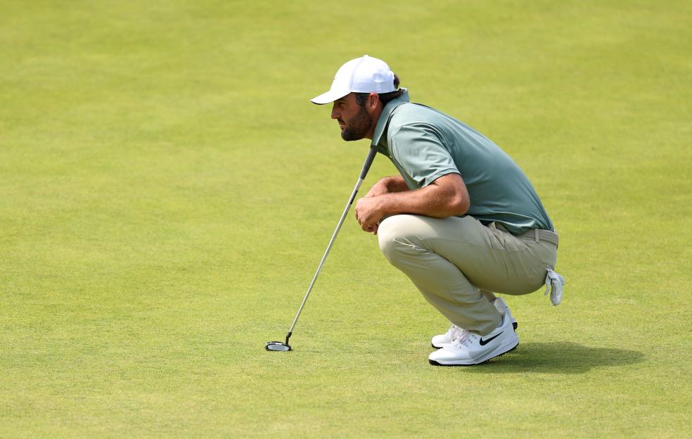 Scottie Scheffler lining up a putt on the green.