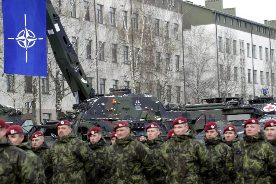 NATO soldiers in camouflage uniforms at a welcoming ceremony in Lithuania.