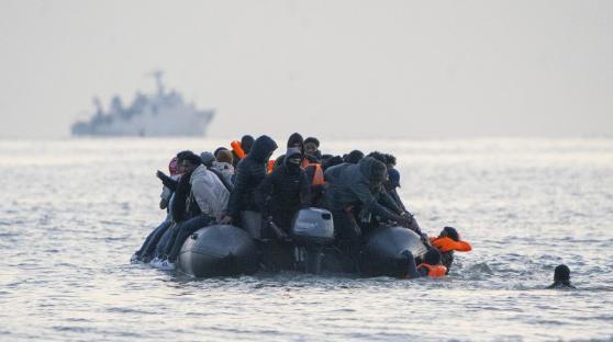 Migrants in an inflatable boat at sea.