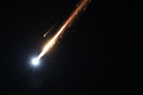 Streak of light in night sky.