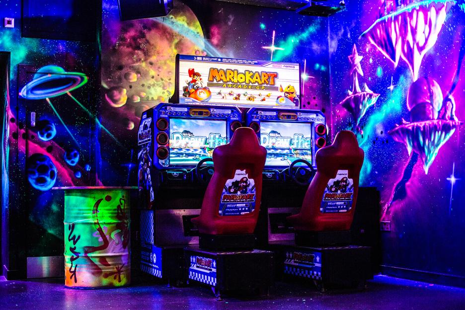 Mario Kart Arcade GP Deluxe arcade game in a brightly lit room.