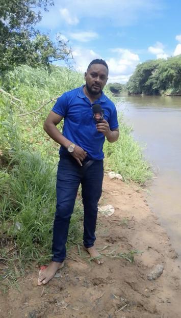 Reporter at riverbank reporting on missing girl.