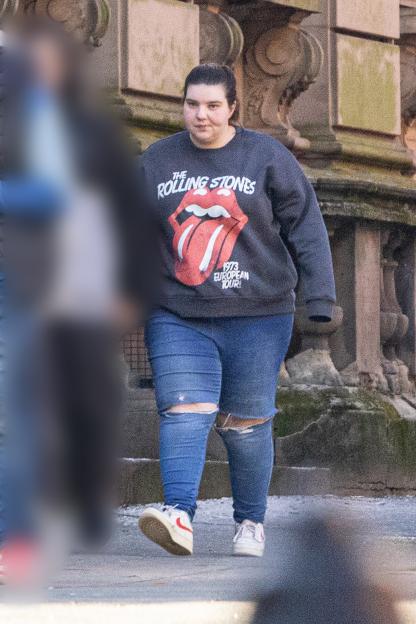 Woman wearing a Rolling Stones sweatshirt leaving court.