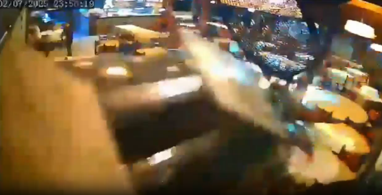 Security camera footage of a blurry altercation in a restaurant.