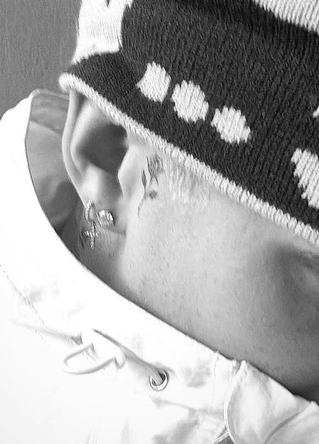 Black and white photo of Romeo Beckham's new tattoo behind his ear.