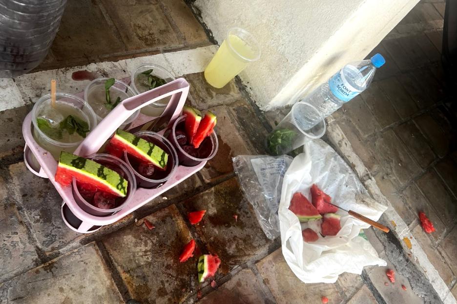 Cocktails prepared unsafely with watermelon and other ingredients on the ground.