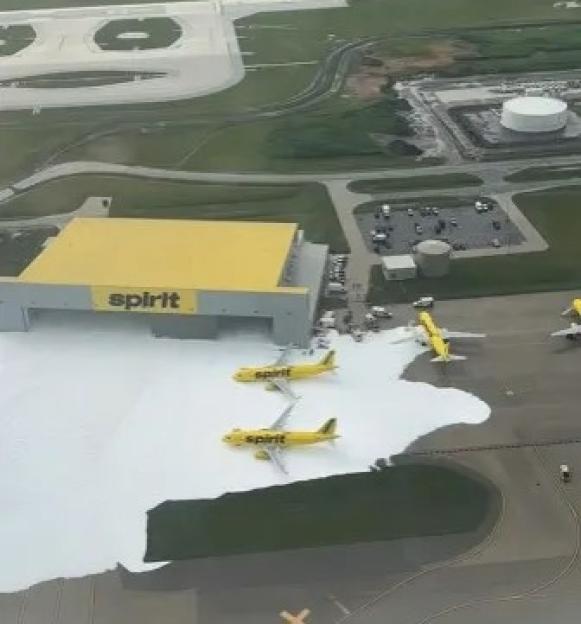 Aerial view of Spirit Airlines planes covered in foam at Detroit Metro Airport.