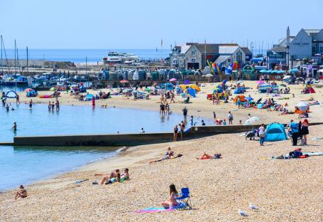 Crowded beach in Lyme Regis, Dorset, UK, on a hot day.