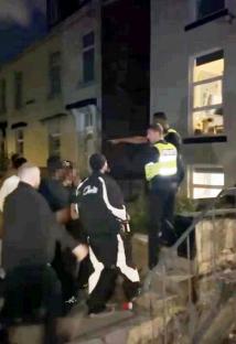 Police officers breaking up a noisy student party.