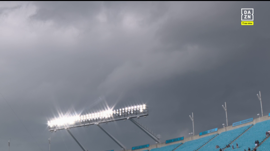 Stadium lights under a stormy sky.