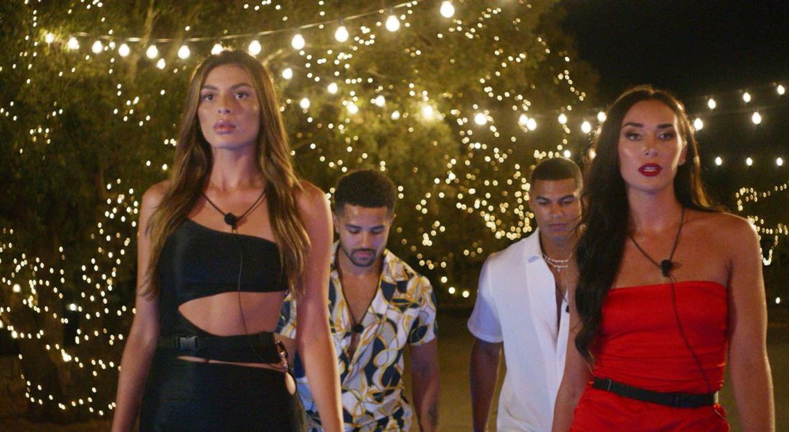 Four Love Island contestants walking at night.