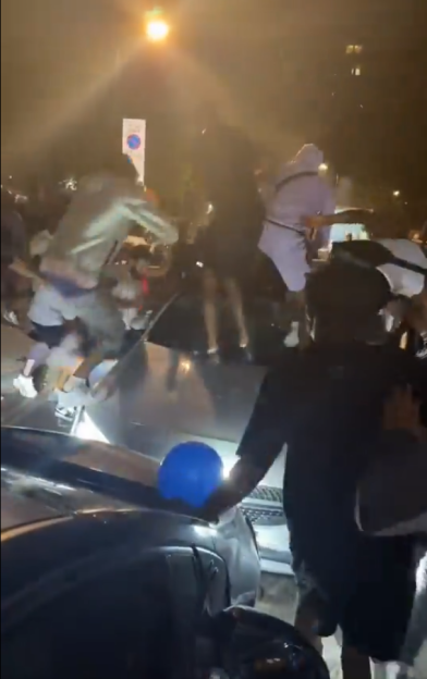 A gang attacking a car.