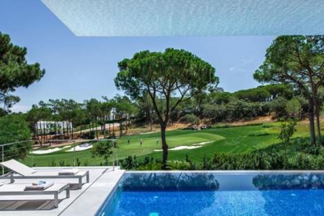 Luxury villa with infinity pool overlooking a golf course.
