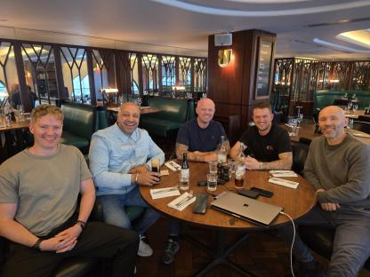 Five men sitting around a table in a restaurant.