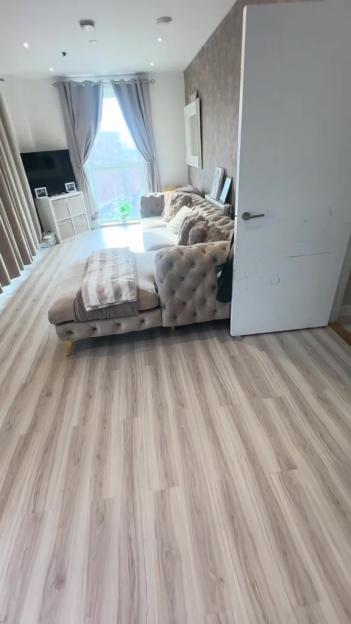 Living room with new laminate flooring and sectional sofa.
