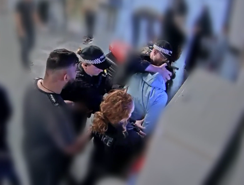 Police officers arresting a person at an airport.