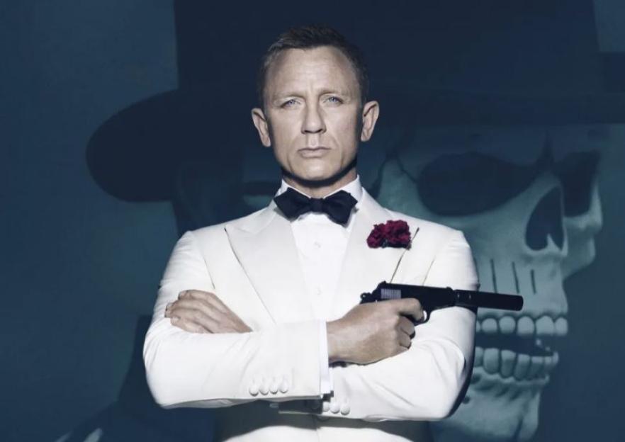 Daniel Craig as James Bond in a white tuxedo, holding a gun.