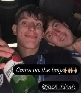 Two young men in a car, one holding a beer bottle.