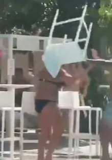 Person carrying a chair on their head.