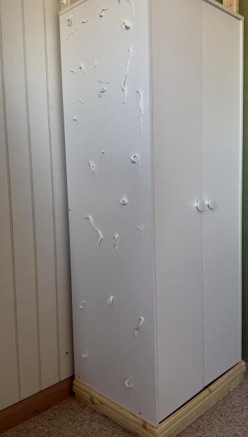 DIY wardrobe with wood base and white doors; one side shows uneven application of white filler.