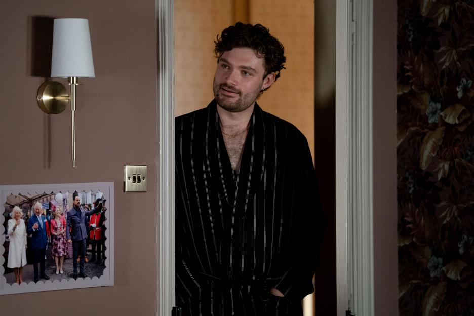 Johnny Carter in a striped robe in an EastEnders scene.