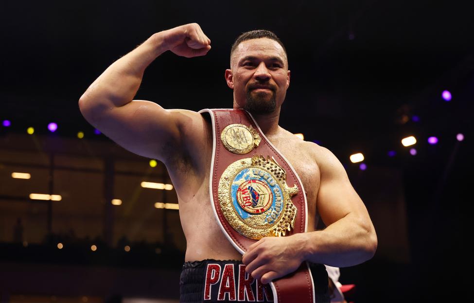 Joseph Parker celebrates a boxing victory with a championship belt.