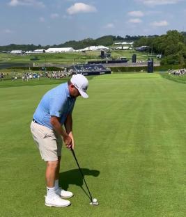 Golfer about to putt on a golf course.