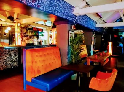 Interior of a bar with orange and blue seating.