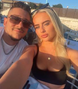 Selfie of a young couple at an outdoor restaurant.
