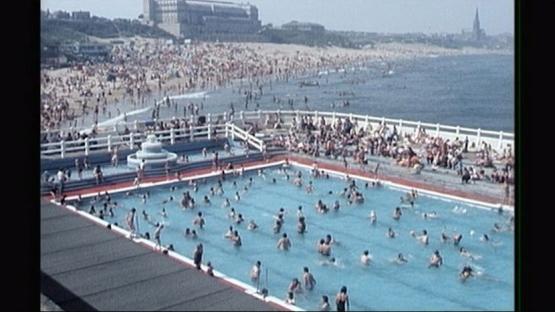Tynemouth Pool crowded with swimmers and beachgoers.