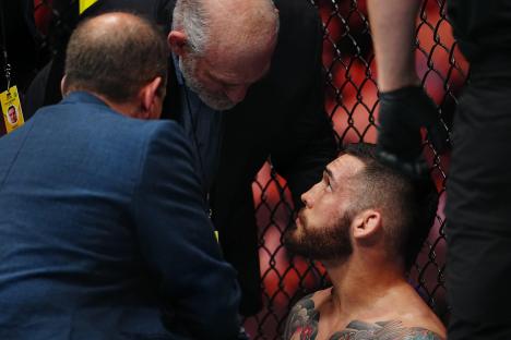 A fighter being attended to by officials after a UFC match.