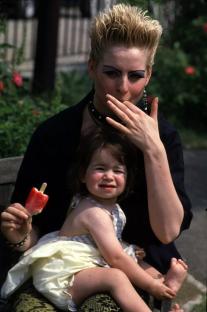 Mary Smith, played by Linda Davidson in Eastenders, holding a toddler.