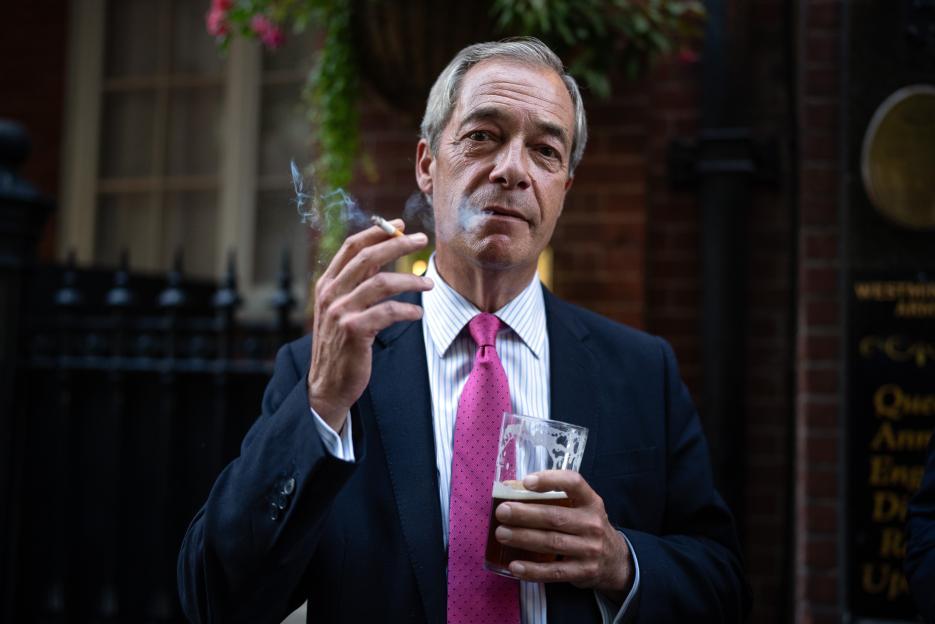 Nigel Farage smoking a cigarette and drinking a pint outside a pub.