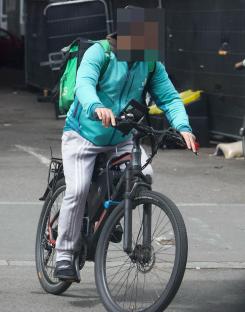 A food delivery cyclist leaving a hotel.