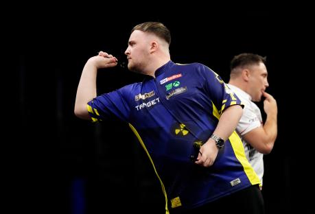Luke Littler throwing darts during a match.