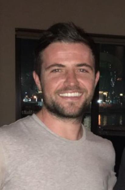 Headshot of a smiling man.