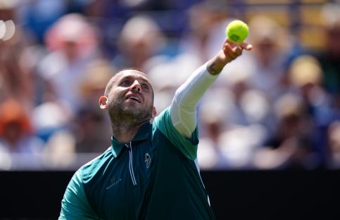 Dan Evans serving a tennis ball.