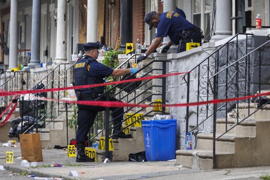 Crime scene investigators collecting evidence at a shooting scene.