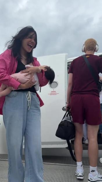 Woman holding a baby at an airport gate.