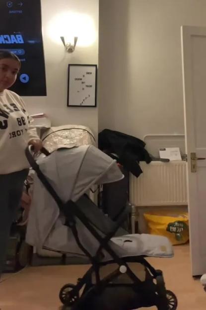 Woman unfolding a gray stroller.